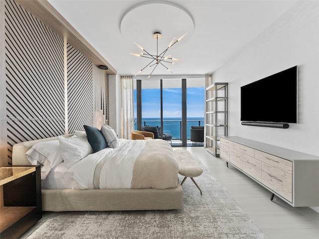 bedroom featuring access to exterior, light hardwood / wood-style flooring, a chandelier, and a wall of windows