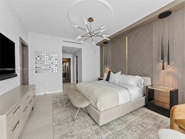 bedroom with light wood-type flooring and a chandelier