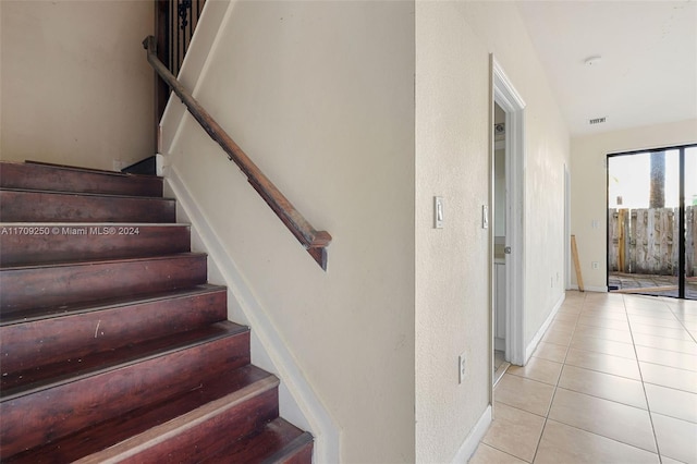 staircase featuring tile patterned flooring