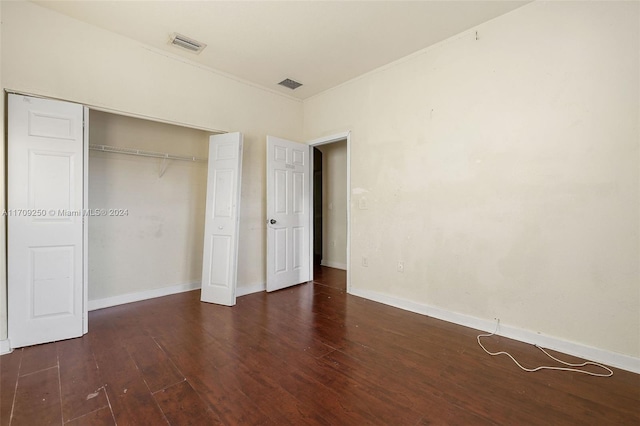 unfurnished bedroom with a closet and dark wood-type flooring