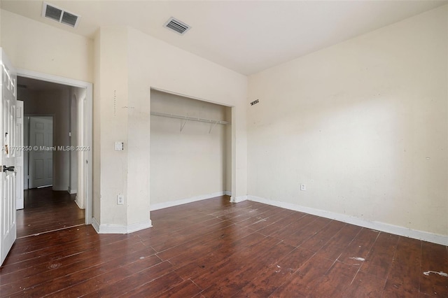 unfurnished bedroom with dark hardwood / wood-style floors and a closet