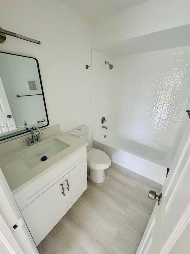 full bathroom with hardwood / wood-style flooring, vanity, toilet, and shower / washtub combination