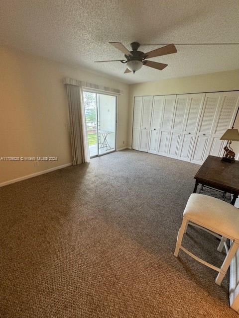 interior space featuring a textured ceiling, ceiling fan, access to outside, and carpet floors