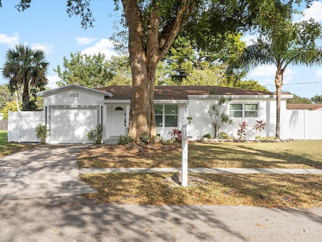 single story home featuring a garage and a front lawn