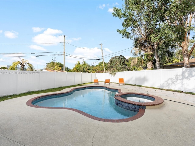 view of pool featuring a patio area and an in ground hot tub