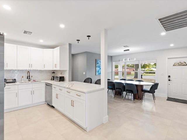 kitchen featuring white cabinets, sink, stainless steel dishwasher, decorative backsplash, and kitchen peninsula