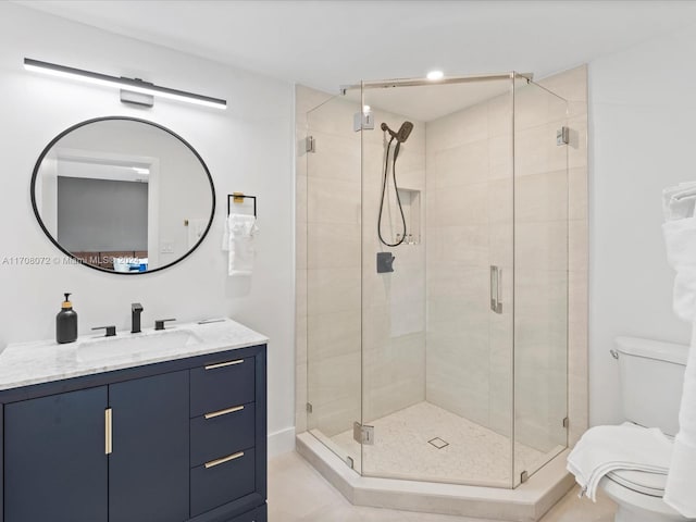 bathroom with tile patterned flooring, vanity, toilet, and a shower with shower door