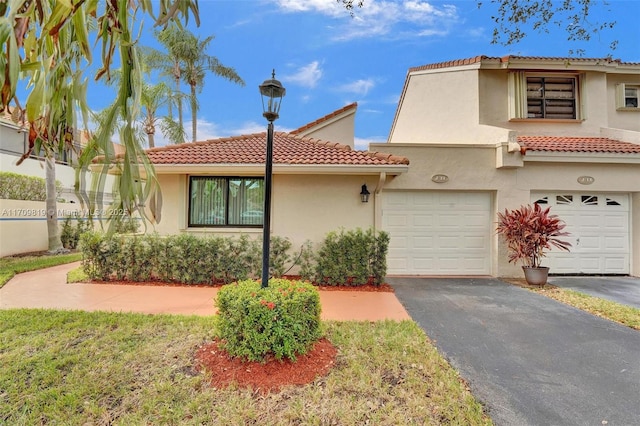 view of front of property featuring aphalt driveway, a tile roof, and stucco siding