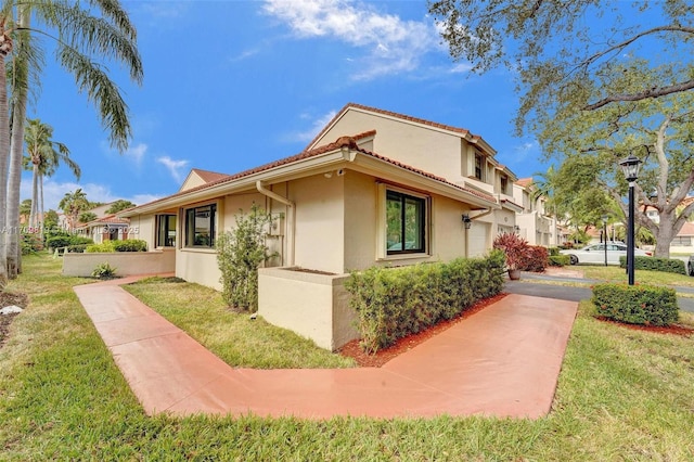 view of home's exterior featuring a lawn, stucco siding, and concrete driveway