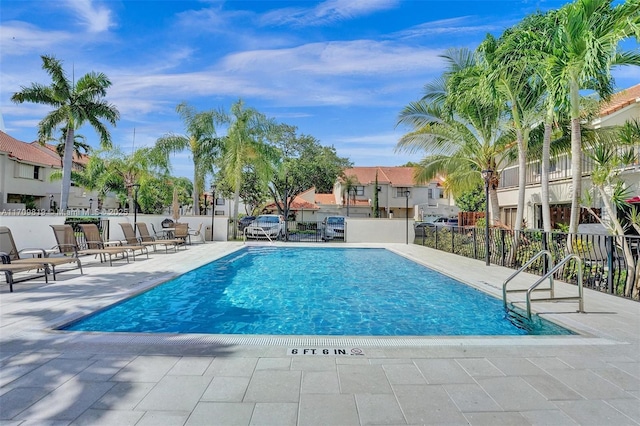 pool with a patio and fence