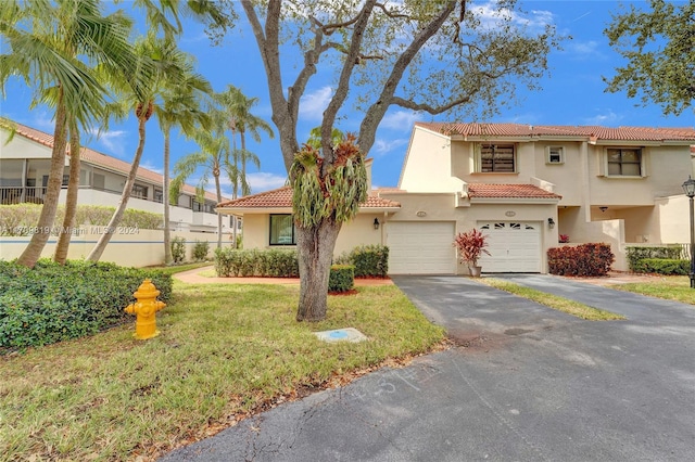 mediterranean / spanish-style home with a garage and a front yard