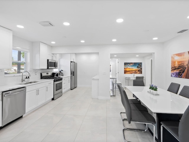 kitchen featuring a breakfast bar, sink, a kitchen island, and stainless steel appliances