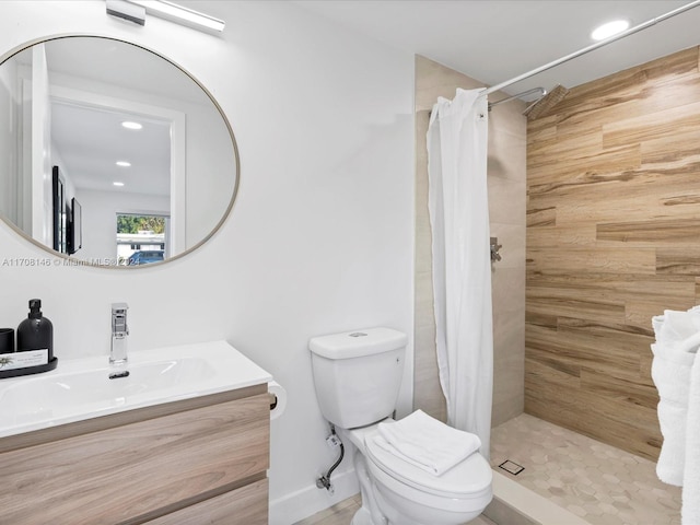 bathroom featuring vanity, toilet, and walk in shower