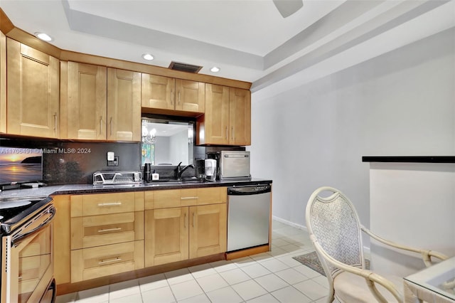 kitchen featuring sink, stainless steel appliances, a raised ceiling, decorative backsplash, and light tile patterned flooring