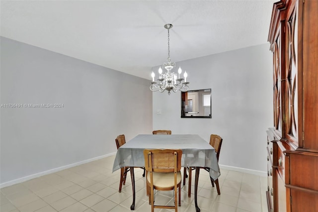 tiled dining area featuring a chandelier