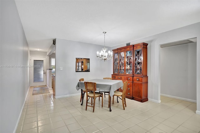 dining area featuring light tile patterned floors and an inviting chandelier