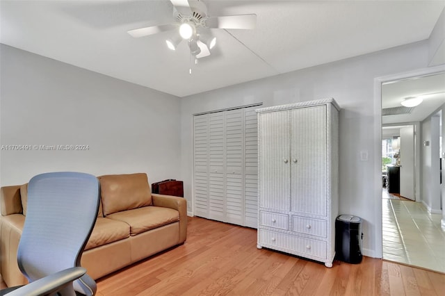 sitting room with ceiling fan and light wood-type flooring