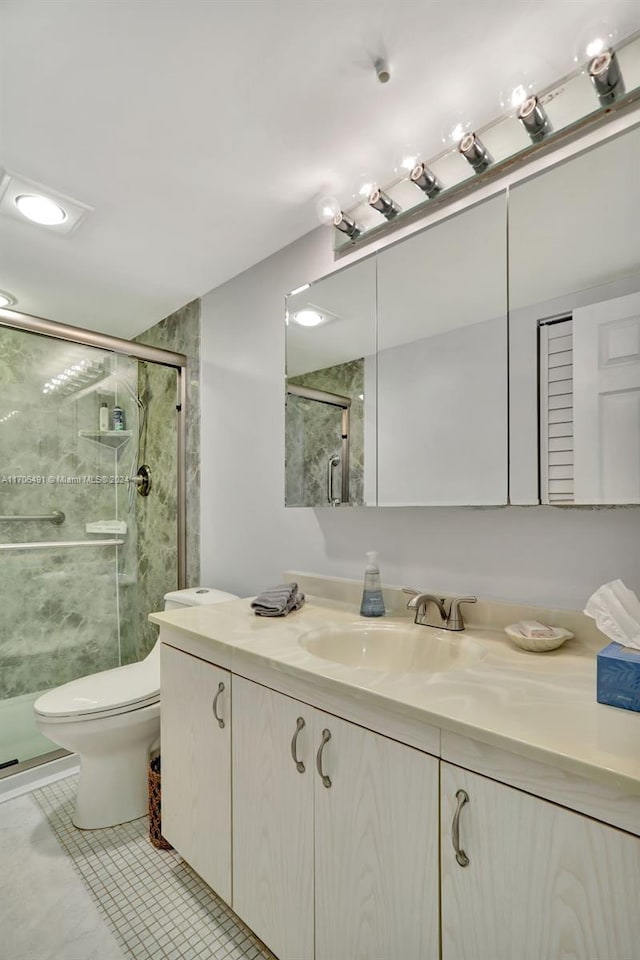 bathroom featuring tile patterned floors, vanity, toilet, and walk in shower