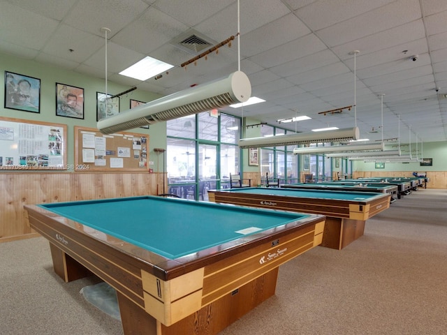 game room with wooden walls, a drop ceiling, light colored carpet, and pool table