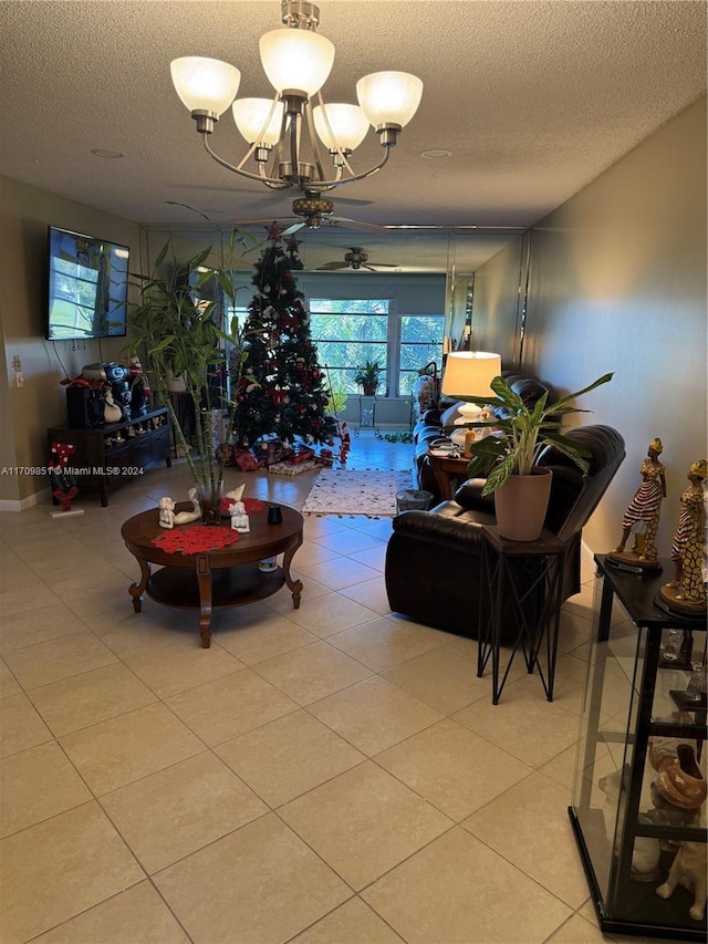 living room featuring ceiling fan with notable chandelier, light tile patterned floors, and a textured ceiling