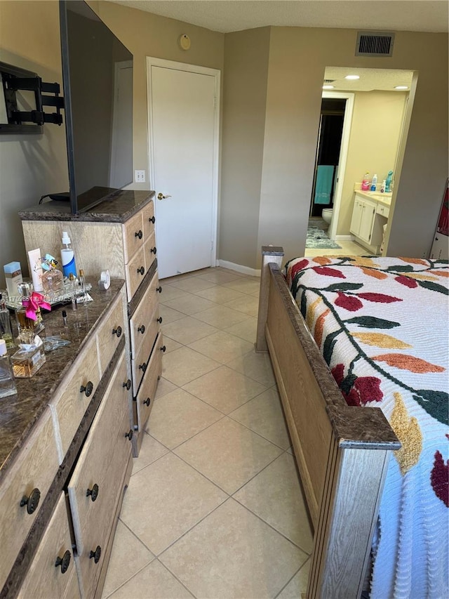 bedroom featuring connected bathroom and light tile patterned floors