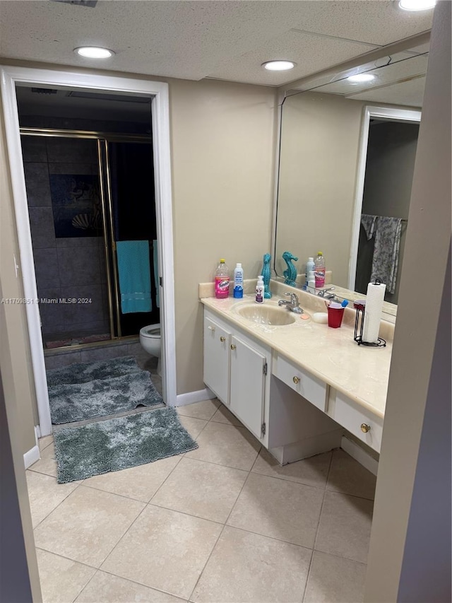 bathroom with tile patterned floors, vanity, toilet, and a shower with shower door