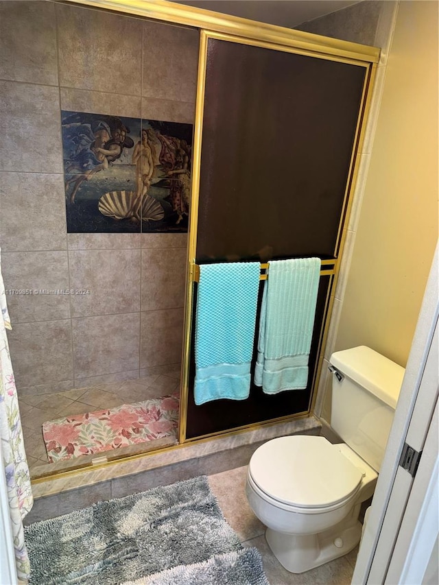 bathroom with tile patterned flooring, toilet, and a shower with shower door