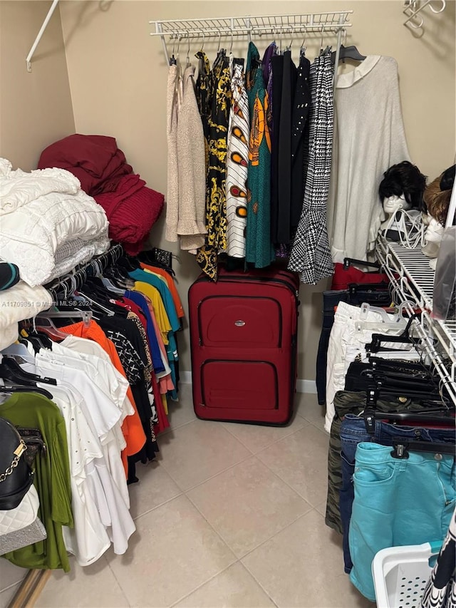 walk in closet with light tile patterned floors