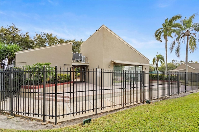 exterior space featuring a gate, fence, and stucco siding