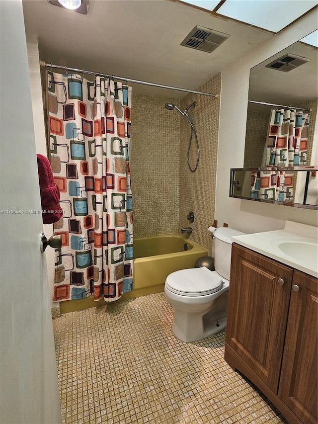 full bathroom featuring vanity, shower / tub combo with curtain, tile patterned flooring, and toilet