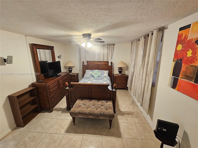 bedroom featuring ceiling fan, light tile patterned floors, and a textured ceiling