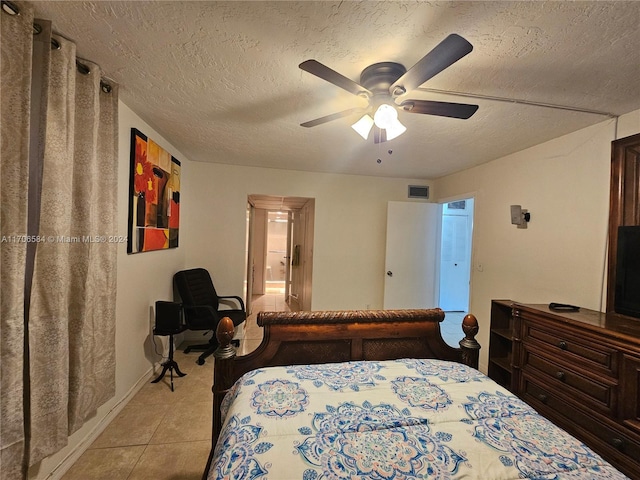 tiled bedroom featuring a textured ceiling and ceiling fan