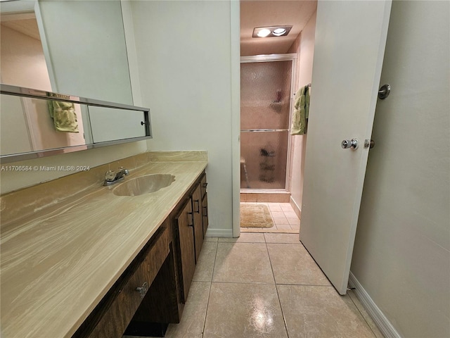 bathroom featuring tile patterned flooring, vanity, and walk in shower