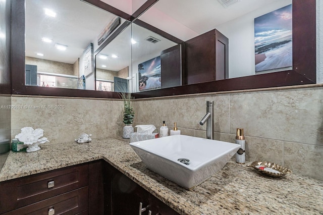 bathroom with vanity, an enclosed shower, and backsplash