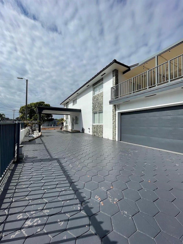 view of property exterior with a balcony and a garage