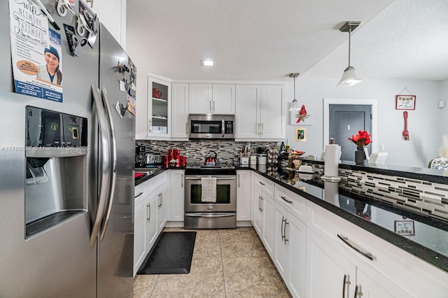 kitchen with hanging light fixtures, light tile patterned floors, appliances with stainless steel finishes, tasteful backsplash, and white cabinetry