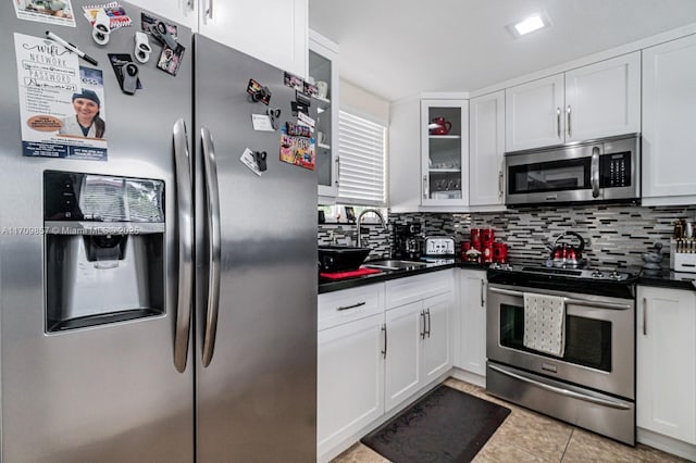 kitchen with white cabinets, sink, light tile patterned floors, and stainless steel appliances