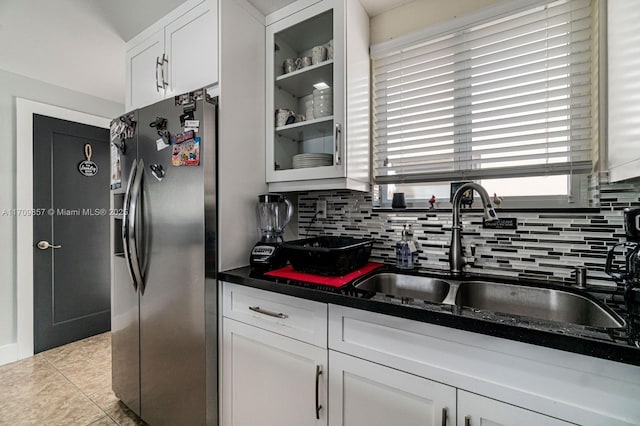 kitchen featuring white cabinets, sink, decorative backsplash, light tile patterned floors, and stainless steel fridge with ice dispenser