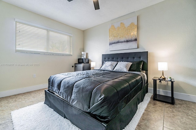 tiled bedroom featuring ceiling fan and a textured ceiling