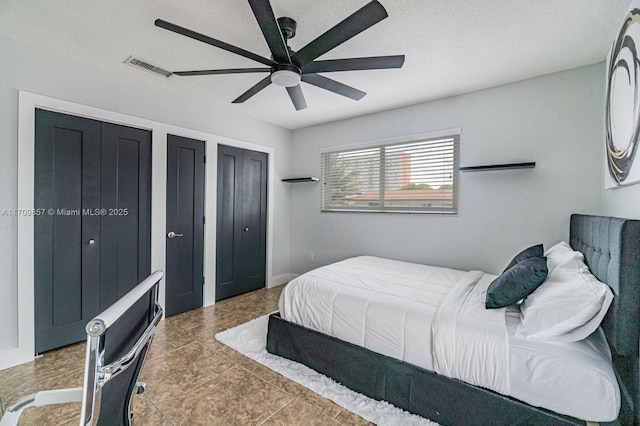 bedroom featuring ceiling fan and multiple closets