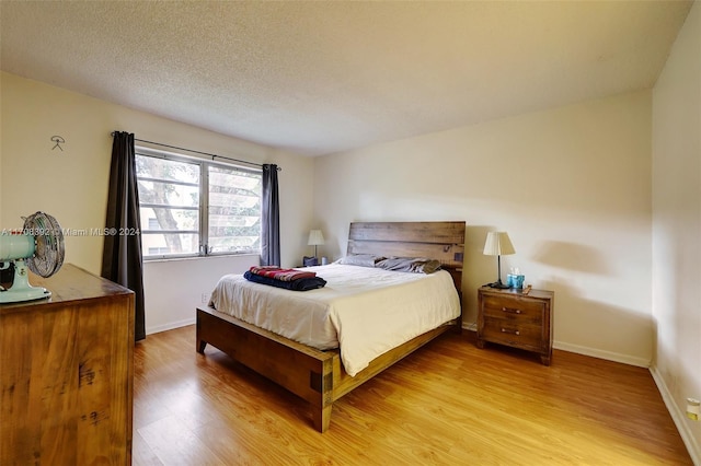 bedroom featuring wood-type flooring and a textured ceiling