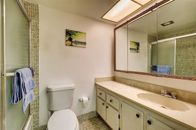 full bathroom with shower / bath combination with glass door, tile patterned flooring, vanity, and toilet