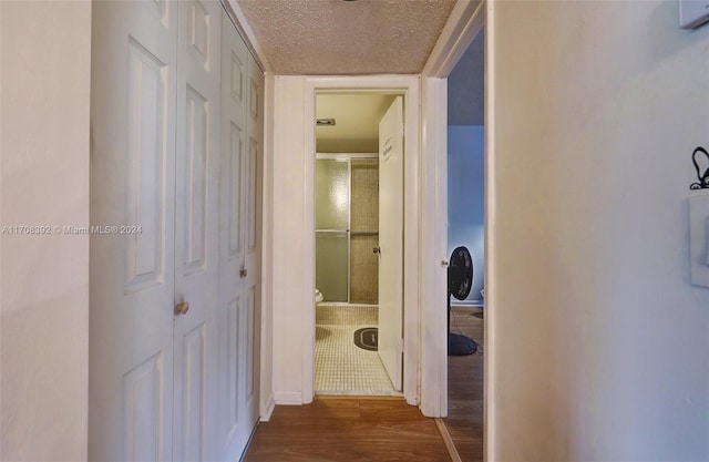 corridor featuring hardwood / wood-style floors and a textured ceiling