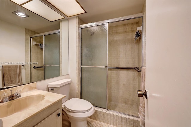 bathroom with tile patterned flooring, vanity, toilet, and walk in shower