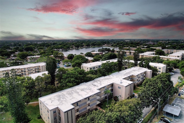 aerial view at dusk featuring a water view