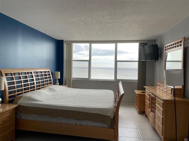 tiled bedroom with multiple windows and a textured ceiling