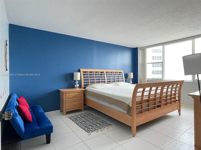 bedroom with light tile patterned floors and a textured ceiling