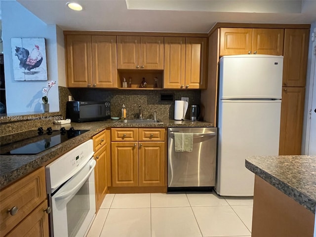 kitchen with backsplash, sink, light tile patterned floors, and black appliances