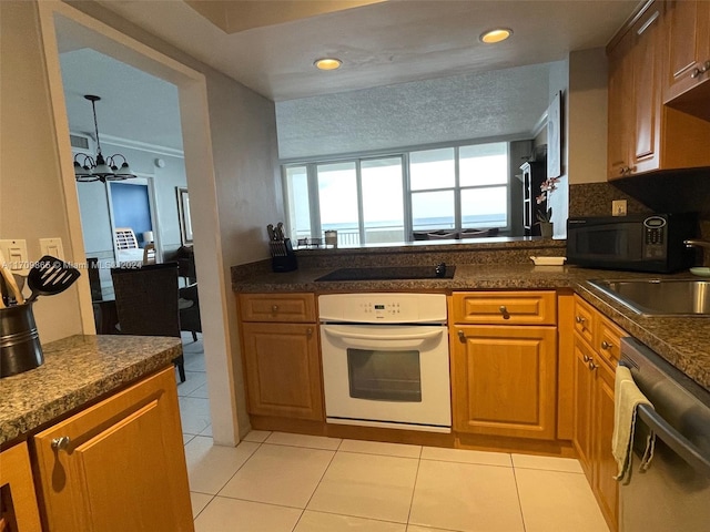 kitchen with light tile patterned flooring, sink, a notable chandelier, and black appliances