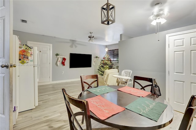 dining area with ceiling fan and light hardwood / wood-style floors